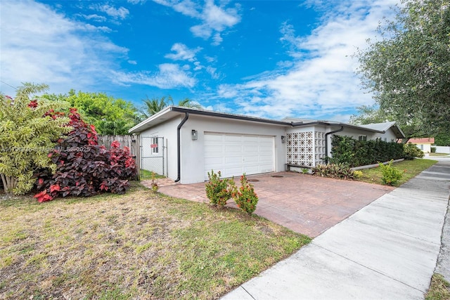 2221 N 46th Ave, Hollywood, FL 33021 - view of home's exterior with an attached garage, stucco siding, decorative driveway, a gate, and fence