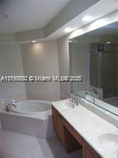 2901 NW 126th Ave Unit 2-325, Sunrise, FL 33323 - bathroom featuring a bath, double vanity, and a shower stall