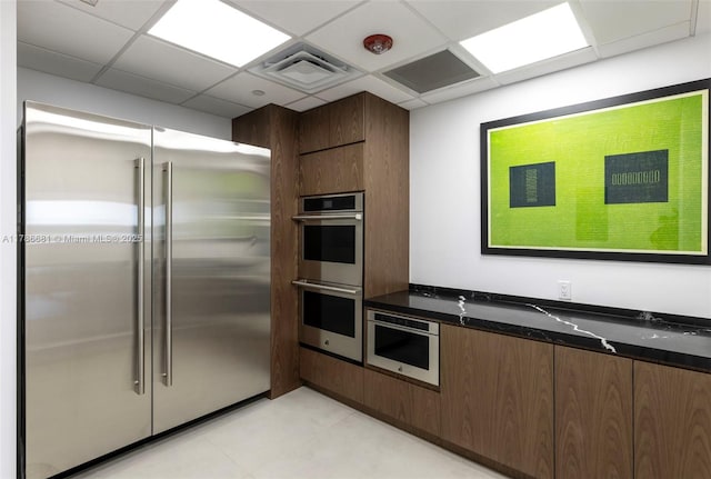 11 Island Ave Unit 512, Miami Beach, FL 33139 - kitchen with stainless steel appliances, dark stone countertops, and modern cabinets
