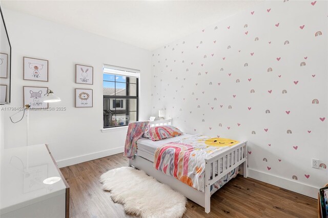 bedroom with wood finished floors and baseboards