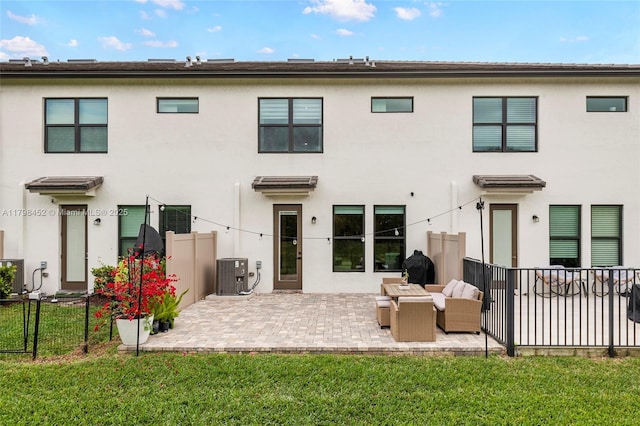 back of property with central AC, stucco siding, and a patio