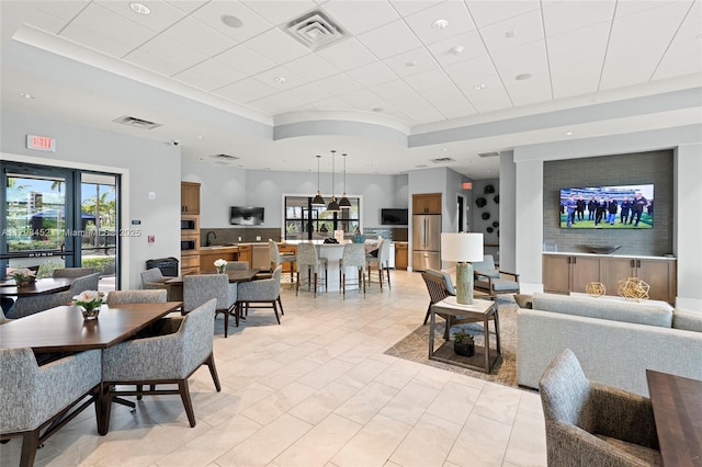 living room featuring a tray ceiling, recessed lighting, and ornamental molding