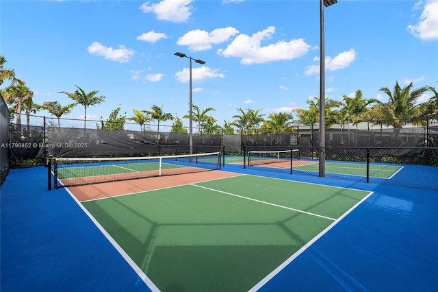 view of tennis court with community basketball court and fence