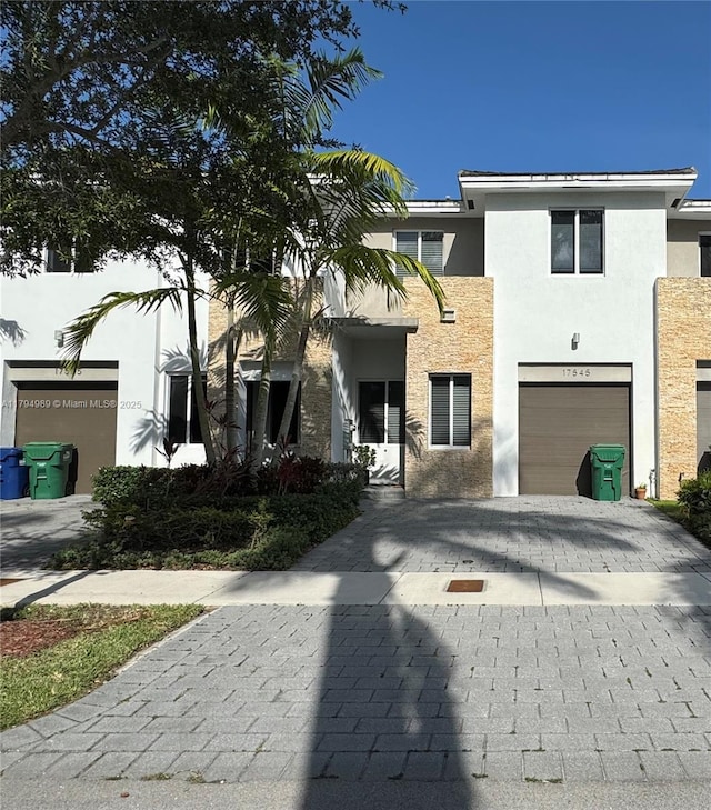 17545 SW 150th Ct, Miami, FL 33187 - view of front of home with stucco siding, decorative driveway, a garage, and stone siding