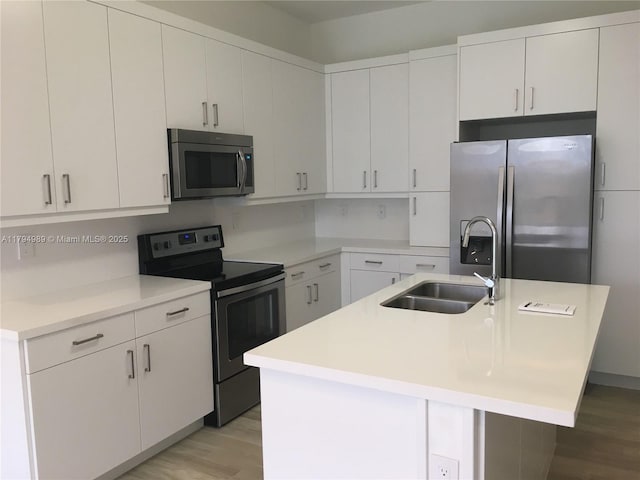 17545 SW 150th Ct, Miami, FL 33187 - kitchen featuring appliances with stainless steel finishes, a sink, light wood-style floors, and a kitchen island with sink