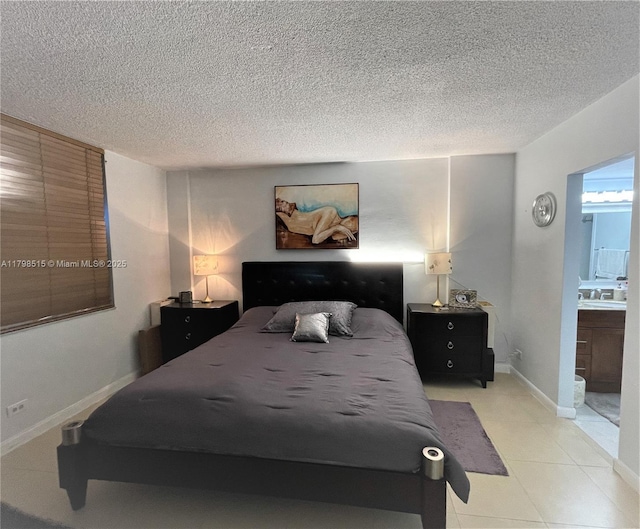 3660 NE 166th St Unit 307, North Miami Beach, FL 33160 - bedroom with a sink, a textured ceiling, ensuite bath, light tile patterned floors, and baseboards