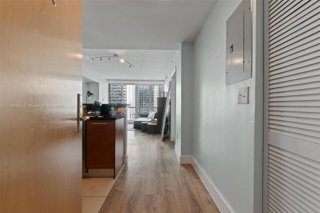 253 NE 2nd St Unit 2201, Miami, FL 33132 - hallway with light wood finished floors, electric panel, track lighting, and baseboards
