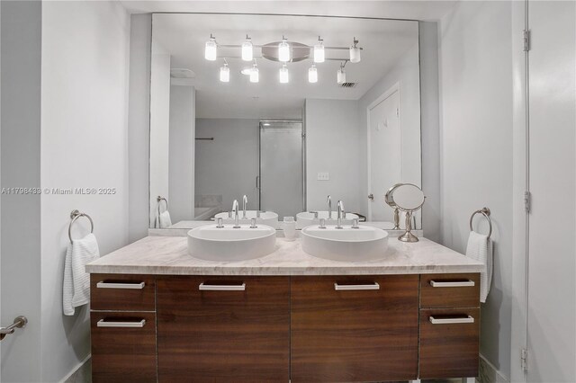 253 NE 2nd St Unit 2201, Miami, FL 33132 - bathroom with a shower stall, double vanity, and rail lighting