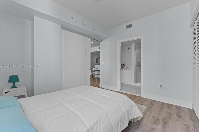 253 NE 2nd St Unit 2201, Miami, FL 33132 - bedroom featuring wood finished floors and ensuite bath