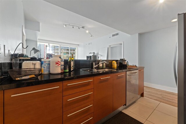 253 NE 2nd St Unit 2201, Miami, FL 33132 - kitchen with stainless steel appliances, light tile patterned floors, and dark countertops