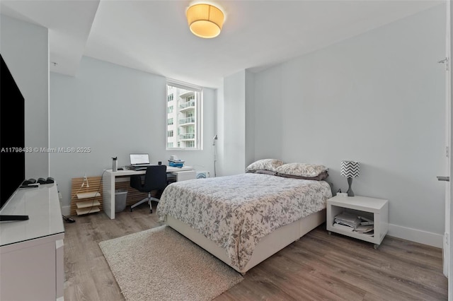 253 NE 2nd St Unit 2201, Miami, FL 33132 - bedroom with a desk, light wood-style flooring, and baseboards