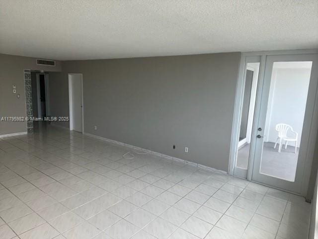 unfurnished room with a textured ceiling and baseboards