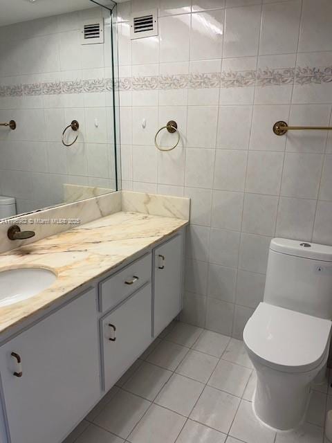 bathroom featuring tile walls, toilet, tile patterned flooring, and vanity
