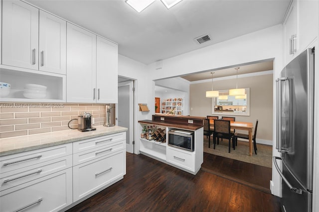 270 NE 104th St, Miami Shores, FL 33138 - kitchen featuring stainless steel appliances, dark wood-style flooring, decorative backsplash, white cabinets, and light stone countertops