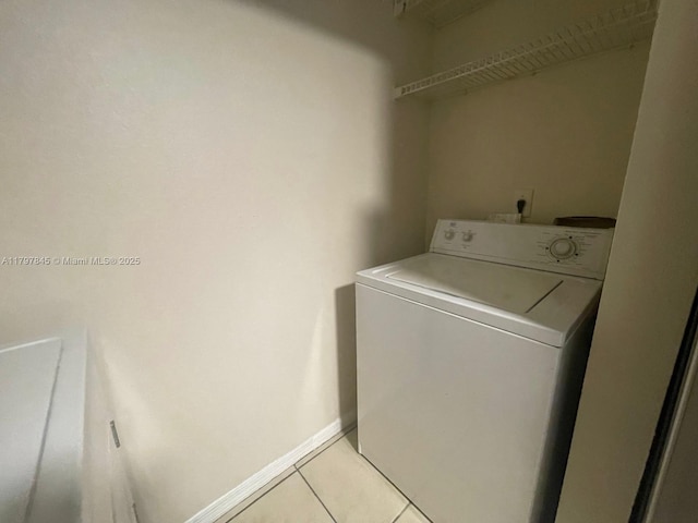 laundry room featuring washer / clothes dryer, light tile patterned floors, and baseboards