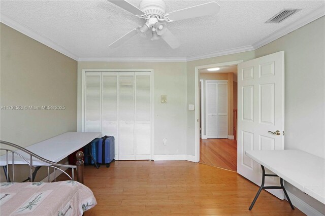 15007 SW 141st Pl, Miami, FL 33186 - bedroom with light wood-style flooring, a textured ceiling, a closet, ornamental molding, and ceiling fan