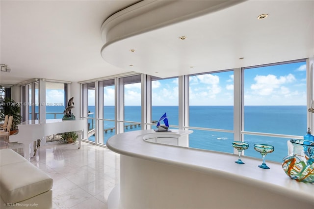kitchen with a water view, expansive windows, and light tile patterned floors