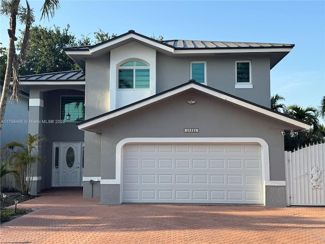 10331 SW 20th Ter, Miami, FL 33165 - view of front facade featuring a standing seam roof, stucco siding, metal roof, and decorative driveway