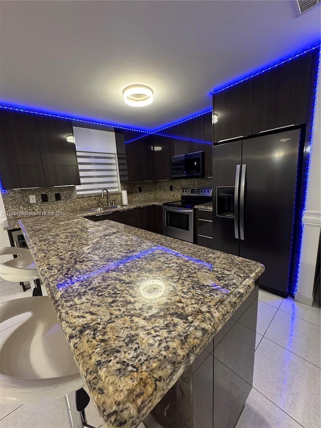 10331 SW 20th Ter, Miami, FL 33165 - kitchen featuring appliances with stainless steel finishes, a sink, modern cabinets, decorative backsplash, and a kitchen breakfast bar
