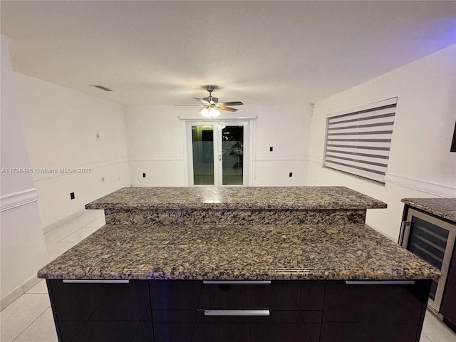 10331 SW 20th Ter, Miami, FL 33165 - kitchen featuring wine cooler, light tile patterned floors, ceiling fan, dark stone counters, and a center island
