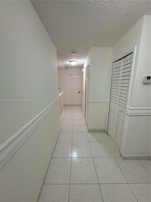 10331 SW 20th Ter, Miami, FL 33165 - hall with a textured ceiling, light tile patterned flooring, and baseboards