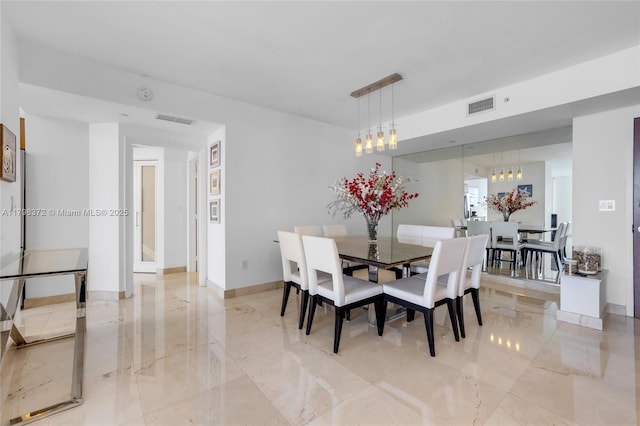 6365 Collins Ave Unit 3202, Miami Beach, FL 33141 - dining room featuring light marble finish flooring, a chandelier, and baseboards