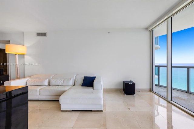 6365 Collins Ave Unit 3202, Miami Beach, FL 33141 - living room featuring expansive windows, a water view, and baseboards