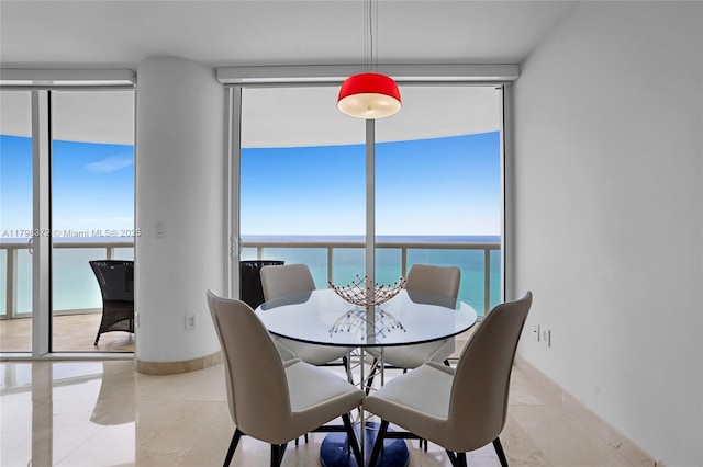 6365 Collins Ave Unit 3202, Miami Beach, FL 33141 - dining area featuring floor to ceiling windows, a water view, and baseboards