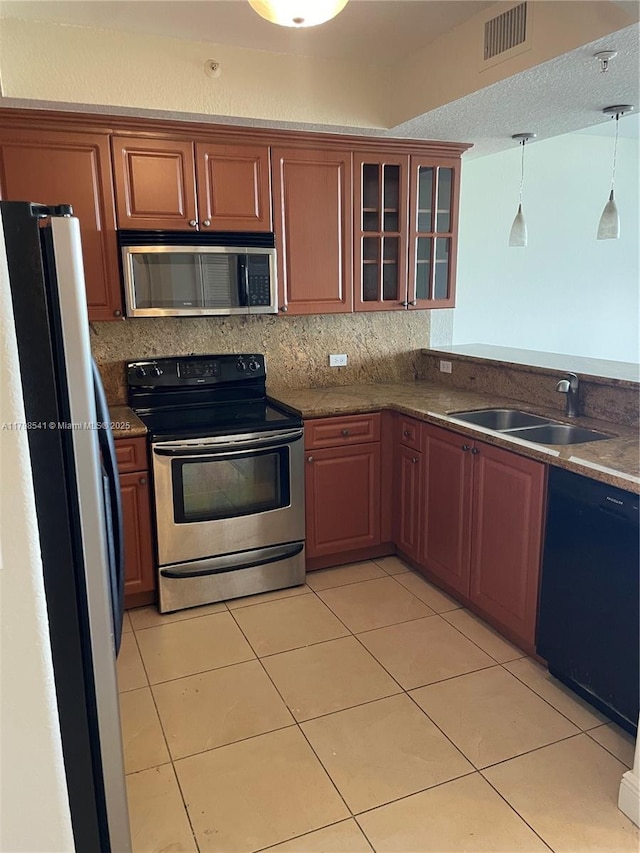 2301 SW 27th Ave Unit 802, Miami, FL 33145 - kitchen with stainless steel appliances, a sink, glass insert cabinets, decorative light fixtures, and light tile patterned floors