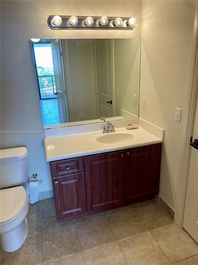 2301 SW 27th Ave Unit 802, Miami, FL 33145 - bathroom featuring a textured wall, vanity, toilet, and baseboards