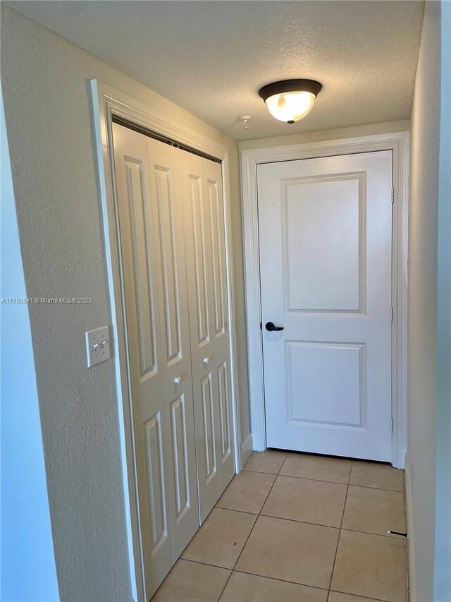 2301 SW 27th Ave Unit 802, Miami, FL 33145 - corridor with light tile patterned floors, a textured ceiling, and baseboards
