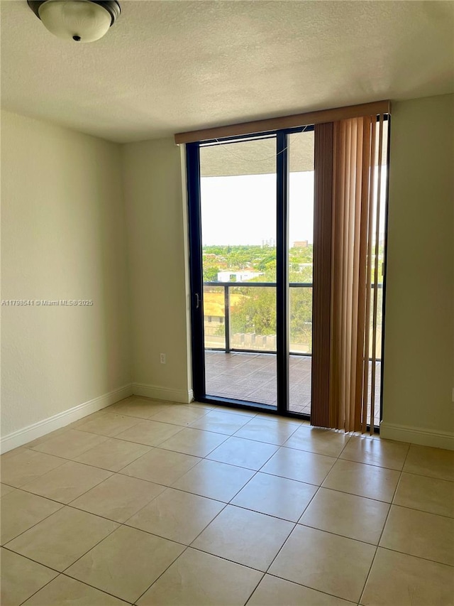 2301 SW 27th Ave Unit 802, Miami, FL 33145 - spare room with a textured ceiling, light tile patterned floors, and baseboards