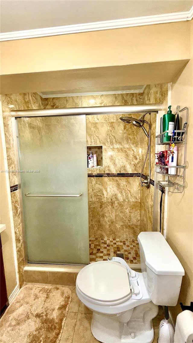 full bath with a shower stall, toilet, tile patterned floors, and crown molding