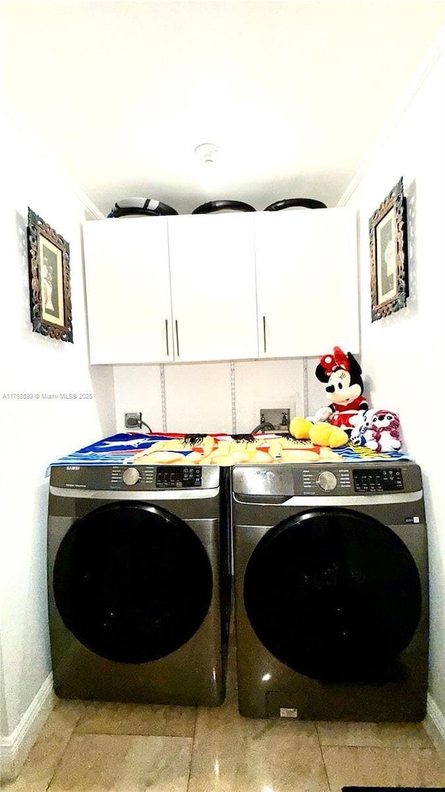laundry area featuring cabinet space, washer and clothes dryer, baseboards, crown molding, and light tile patterned floors