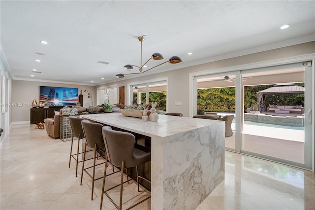 10921 SW 102nd Ct, Miami, FL 33176 - kitchen featuring crown molding, light stone counters, recessed lighting, a breakfast bar area, and a kitchen island