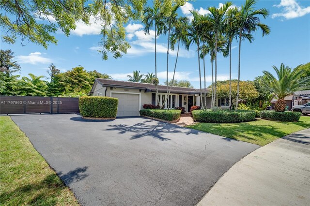 10921 SW 102nd Ct, Miami, FL 33176 - view of front of home featuring a garage, stucco siding, asphalt driveway, fence, and a gate