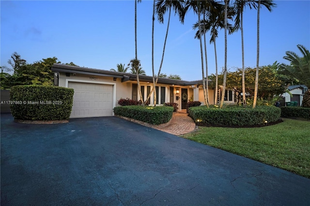 10921 SW 102nd Ct, Miami, FL 33176 - ranch-style house featuring an attached garage, asphalt driveway, stucco siding, and a front yard