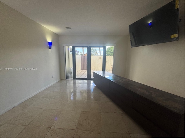 unfurnished room with baseboards