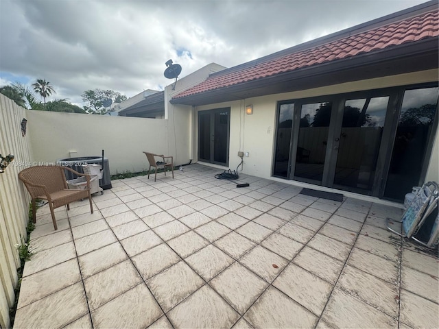 view of patio / terrace with central AC unit, french doors, and fence