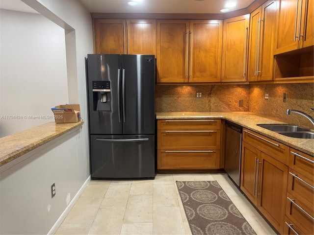kitchen featuring black refrigerator with ice dispenser, a sink, stainless steel dishwasher, and light stone counters