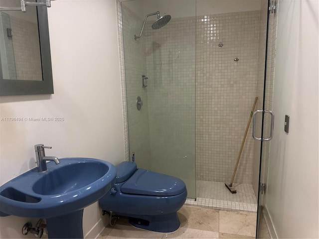 bathroom featuring a stall shower, toilet, a sink, and tile patterned flooring