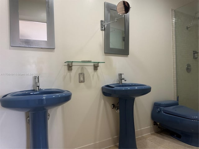full bath featuring a tile shower, baseboards, and toilet