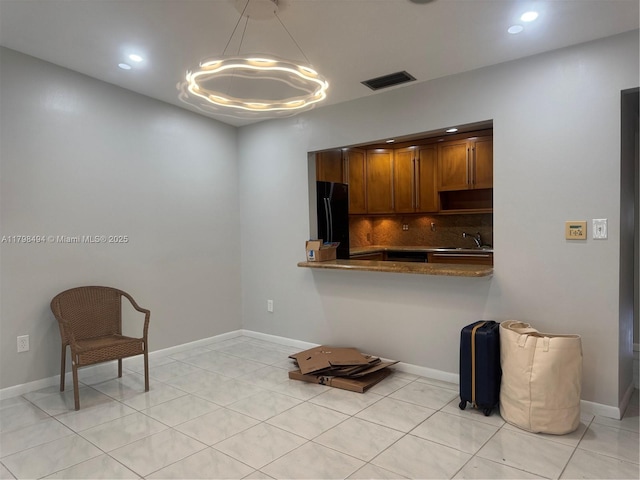 unfurnished room with recessed lighting, light tile patterned floors, baseboards, a chandelier, and a sink
