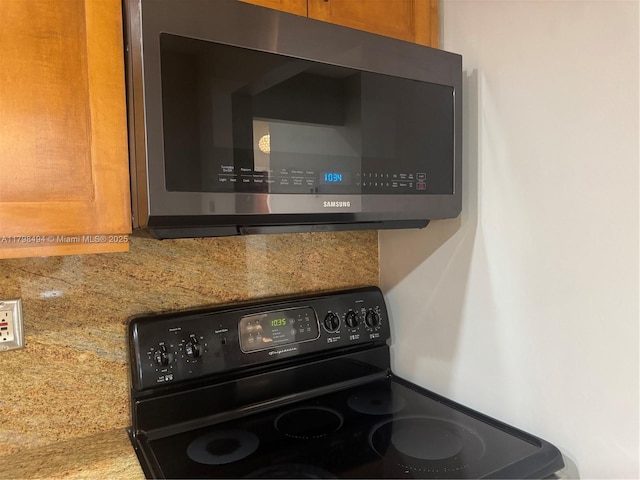 kitchen view of black range with electric cooktop and stainless steel microwave
