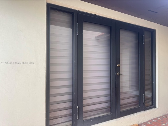 entrance to property featuring french doors and stucco siding
