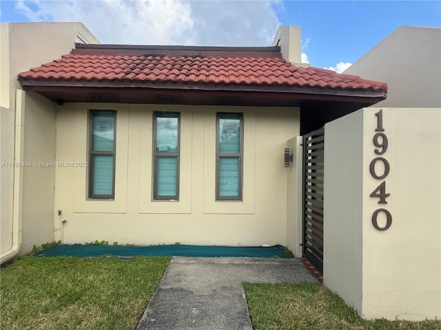 view of side of property with a tiled roof and stucco siding