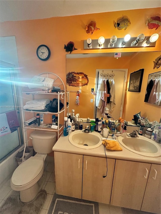 full bathroom featuring toilet, tile patterned flooring, double vanity, and enclosed tub / shower combo
