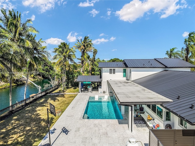 view of swimming pool featuring a patio area, a water view, and a fenced backyard