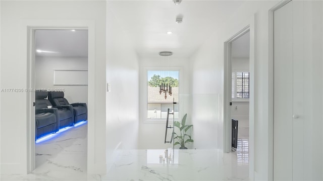 hall with marble tiled flooring, healthy amount of natural light, and recessed lighting