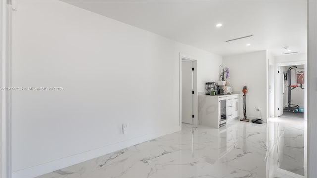 spare room with recessed lighting, light marble finish flooring, and baseboards